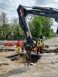 Die beschädigte Hauptwasserleitung unter der Cherbourger Straße wird am Samstagvormittag mit schwerem Gerät freigelegt.