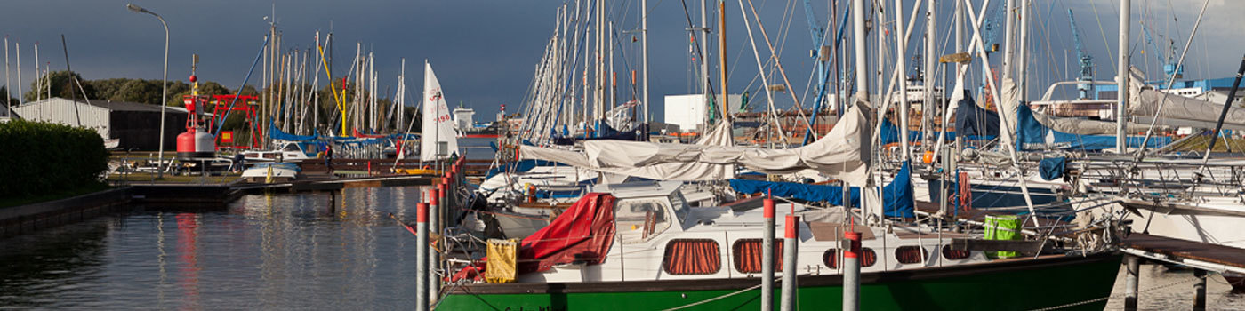 Many sailing ships lie in a marina.
