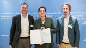 Die Bundesministerin für Wohnen, Stadtentwicklung und Bauwesen, Klara Geywitz, überreichte die Förderurkunde an Stadtrat Martin Günthner (links) sowie an den Leiter des Projekts ELAN, Linus Schindler. 