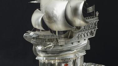 A silver ship on a plate.