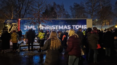 Menschenmenge bei Nacht vor dem beleuchteten Truck mit de Aufschrift "JML Christmas Tour"