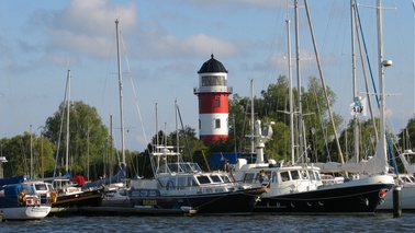 Lighthouse and ships in a marina.