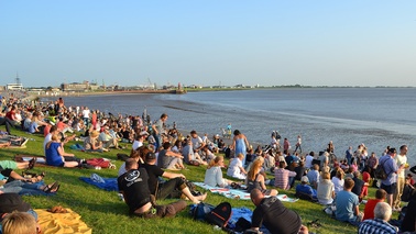 People are sitting on the grass at the dike