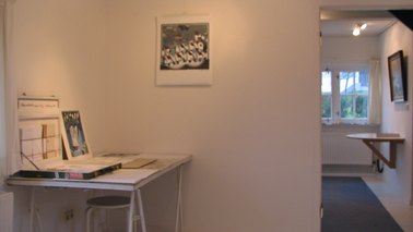 Interior view of the studio, pictures hanging on the wall