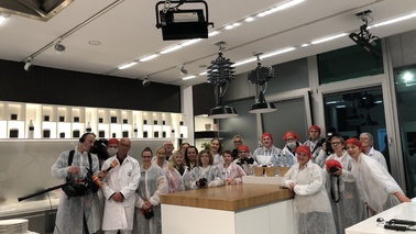 A group of people standing in a kitchen.