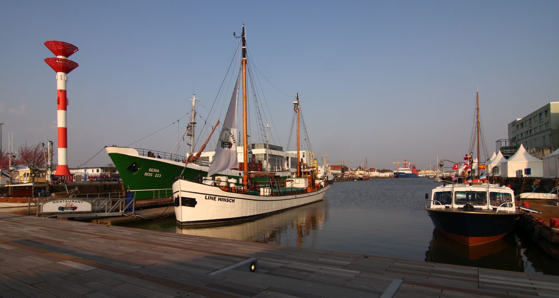 View into a harbour basin with ships at sunset.