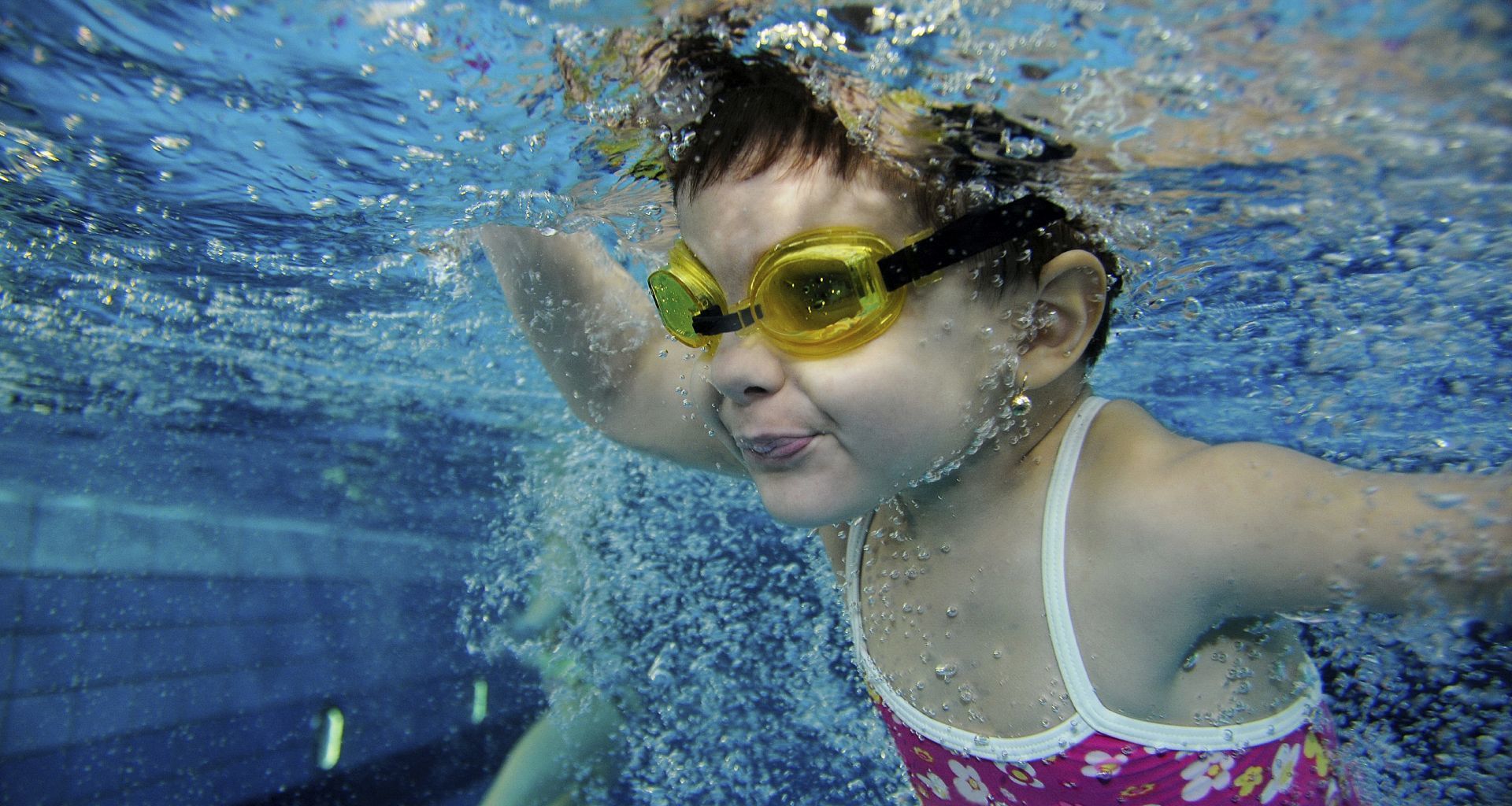 Ein junges Mädchen taucht im Schwimmbad