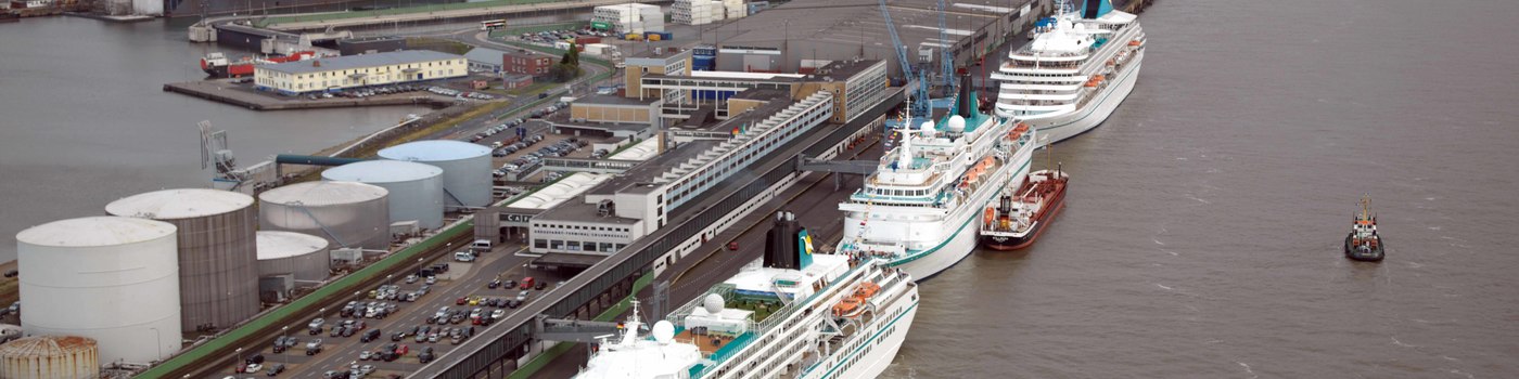 Three cruise ships lie on a terminal.