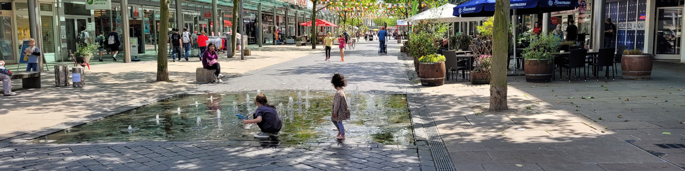 Die Fußgängerzone mit einem Wasserspiel im Vordergrund