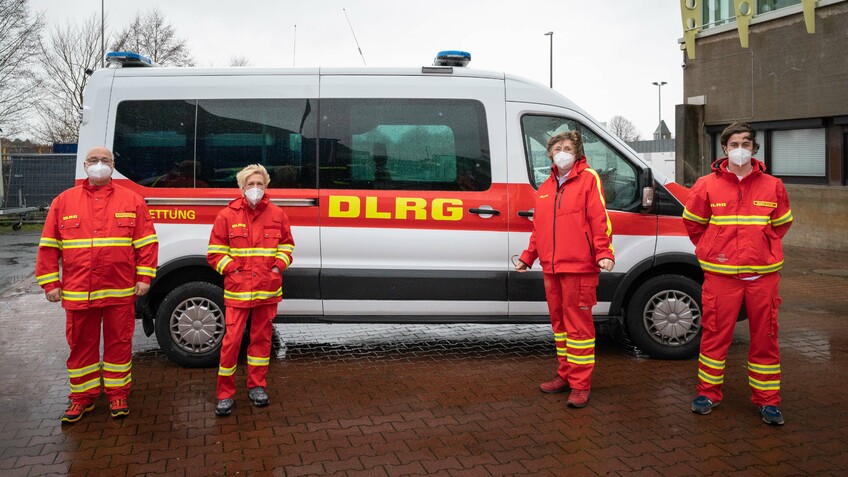 Vier Mitarbeiterinnen und Mitarbeiter des mobilen Impfteams der Deutschen Lebens-Rettungs-Gesellschaft. 