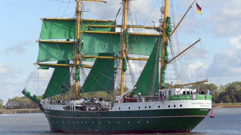 Ein Segelschiff mit grünen Segeln auf einem Törn.