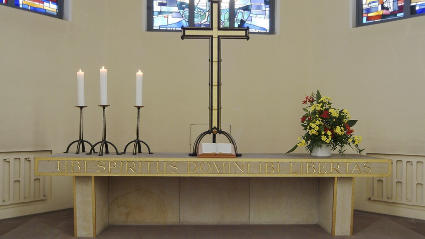 Ein Altar mit Kreuz und Kerzen.