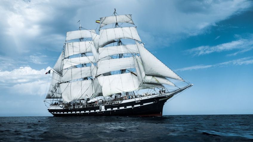A tall ship with sails set.