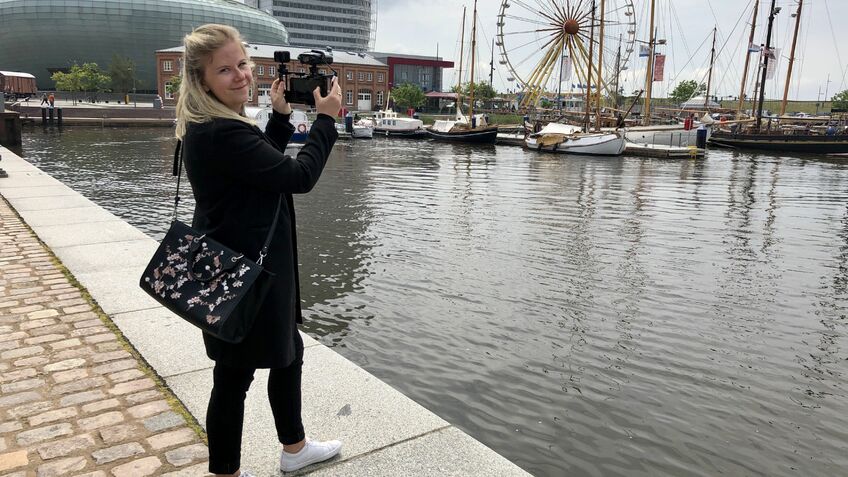 Frau mit Kamera am Hafenbecken