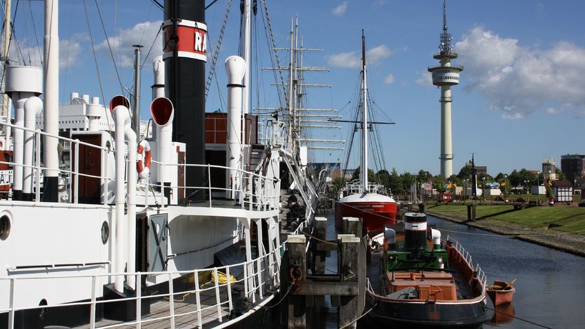 Museumsschiffe liegen in einem Hafenbecken.