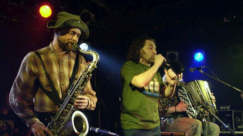Drei Musiker spielen auf einer Bühne.