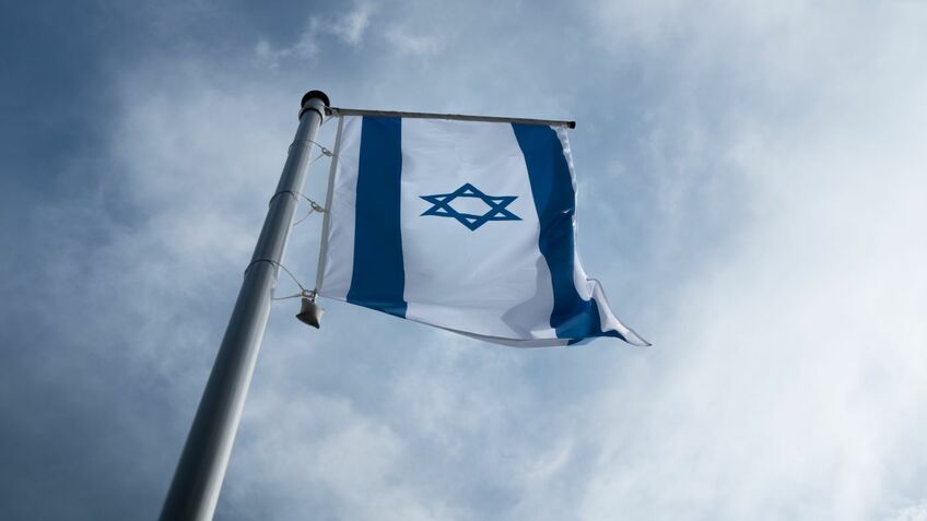 Die Flagge Israels hängt an einem Fahnenmast.