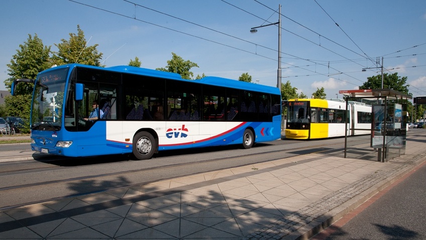 Ein Bus und eine Straßenbahn hält an einer Haltestelle.