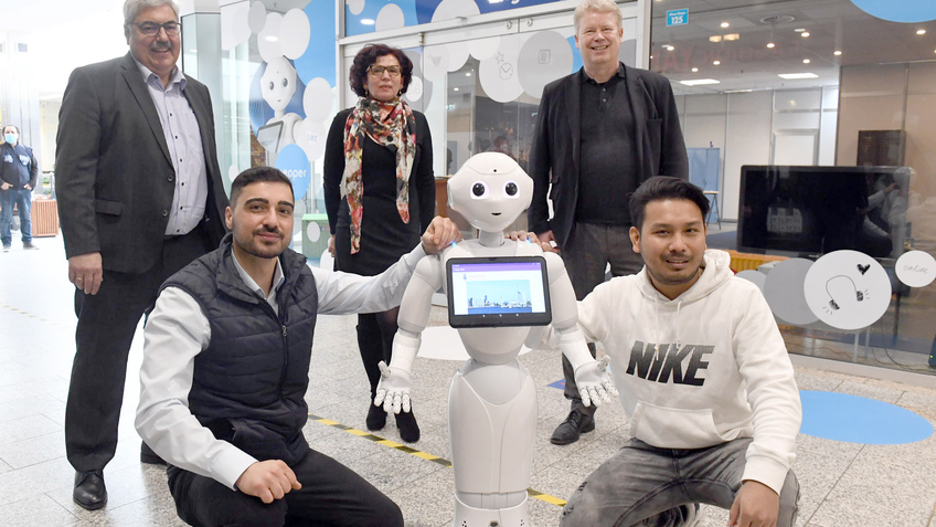5 Menschen und ein humanoider Roboter "Pepper"
