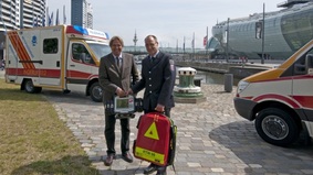 Neue Fahrzeuge für den Rettungsdienst: Stadtrat Jörn Hoffmann (links) übergibt in den Havenwelten die beiden neuen Einsatzwagen an Jens Cordes, Amtsleiter der Feuerwehr.