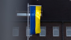 gelb-blaue ukrainische Flagge vor den Stadthäusern
