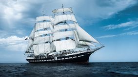 A tall ship with sails set.