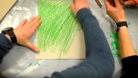 Hände und eine grüne Pappe
