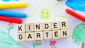 Wachsmalstifte und Buchstabenwürfel, die Kindergarten bilden