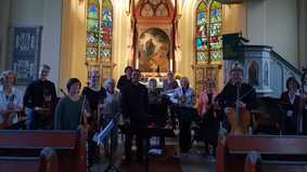 Eine Gruppe von Menschen mit Musikinstrumenten in einer Kirche