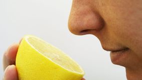 Eine Person riecht an einer Zitrone.