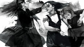 Drei Frauen verschwimmen in fließenden, tänzerischen Bewegungen ineinander. Das Bild ist in schwarz-weiß gehalten.
