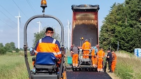 Ordentlich ins Schwitzen kommen die Arbeiter derzeit beim Herstellen der neuen Asphaltschicht für den Radweg „Bütteler Specken“