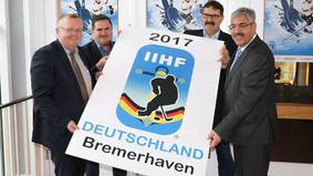 Eishockey-Fan Torsten Neuhoff, hier links im Bild, gemeinsam mit Pinguins-Geschäftsführer Hauke Hasselbring, Teammanager Alfred Prey, sowie Oberbürgermeister Melf Grantz präsentieren das Logo der U20-Eishockey-WM