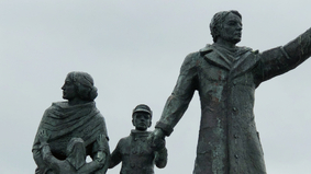 Ein Auswandererdenkmal, dass eine Familie mit Mutter, Vater und zwei Kindern zeigt.