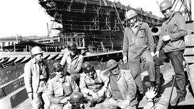 Das Foto von Johannes Fleck zeigt Arbeiter auf der Seebeckwerft vor dem im Bau befindlichen Fabrikfangschiff BX 738 "Geeste" (1972).