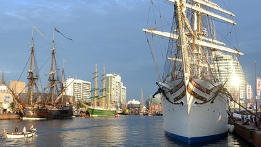 Ships in the New Harbor. Sun is reflected in the Atlantic Hotel Sail City