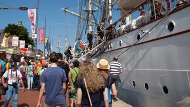 People stroll along the ships