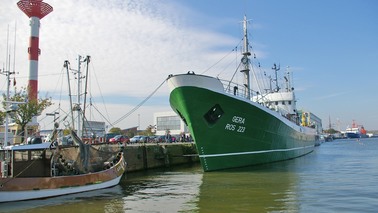 A museum ship lies on a quay.