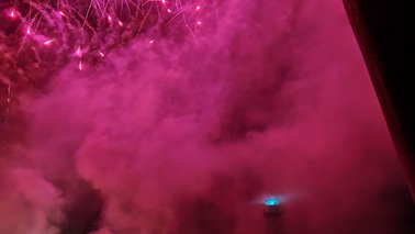 Professionelles Feuerwerk, gezündet von einer Kaimauer im Hafen. Dichter Rauch ist zu sehen.