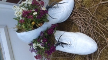 Weiße Schuhe mit Blumen gefüllt. 
