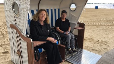 Zwei Frauen im Rollstuhl im Strandkorb