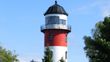 The top of a lighthouse with a balcony.