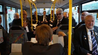 Ein Männerchor singt in einem Bus