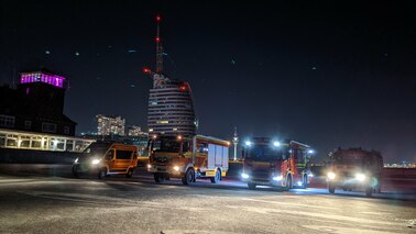 Fahrzeuge der Freiwilligen Feuerwehr Bremerhaven-Lehe vor der Skyline Bremerhavens bei Nacht
