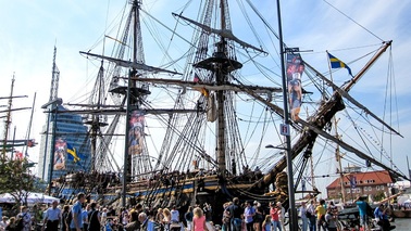 People are standing in front of sailing ship