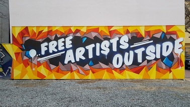 Graffiti mit der Aussage „Free Artists Outside“