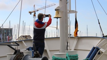 Ein Mann fotografiert die Schiffsglocke auf der Bad Bramstedt
