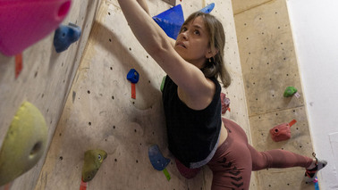 Woman hangs in climbing wall