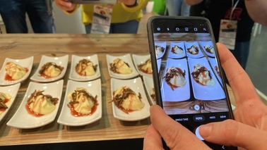 Ein Handy fotografiert hergerichtete Desserts mit Mehlwürmern