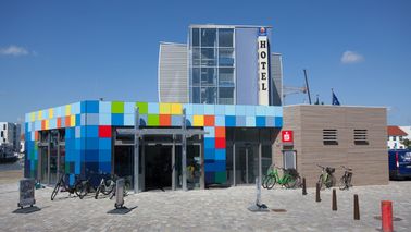  A colorful building, bicycles in front of it.